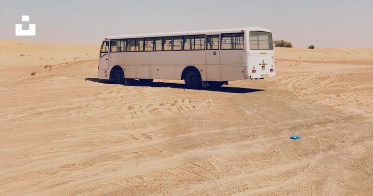 White intercity bus parked in an open landscape