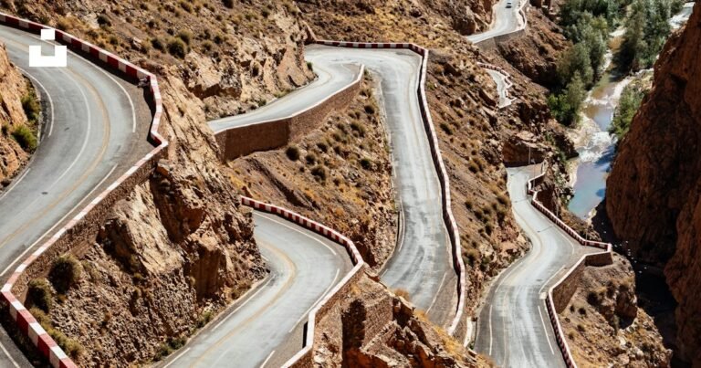 Intercity bus traveling on a desert road toward distant mountains